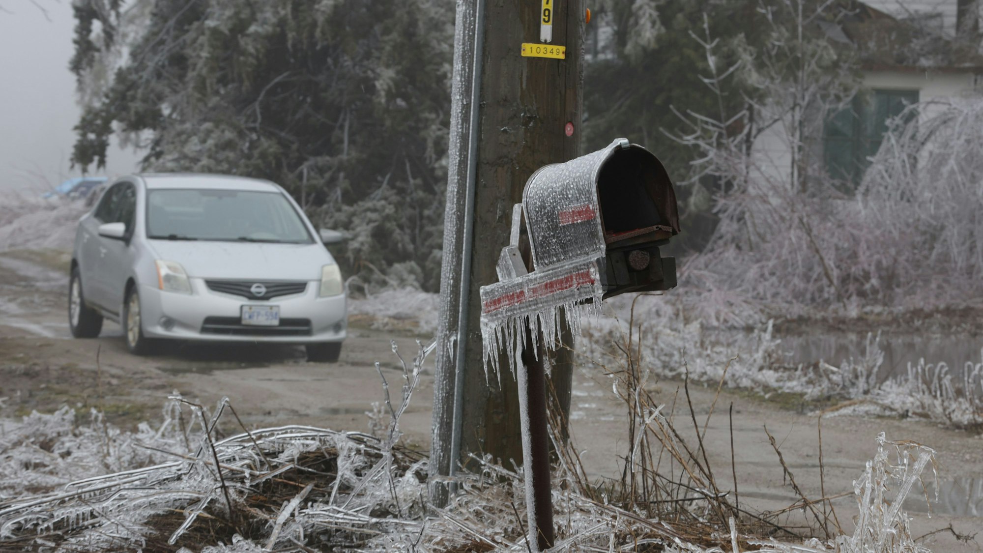 Ein eingefrorener Briefkasten auf einem Bauernhof nach einem Sturm mit Eis, gefrierendem Regen und Schnee.