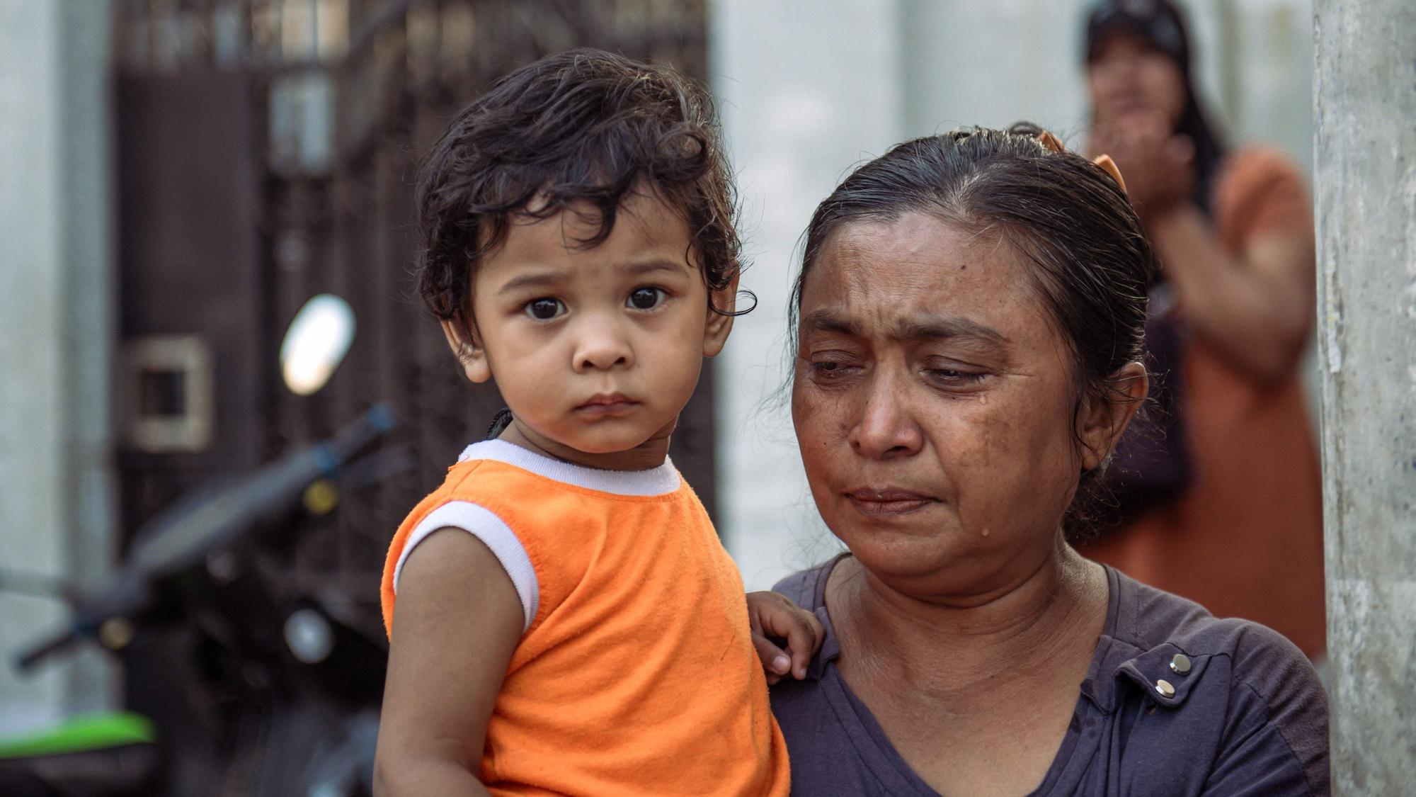 Eine Frau hält in Mandalay nach dem schweren Erdbeben in Myanmar ein Kind auf dem Arm.