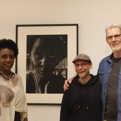 Eine Frau und zwei Männer vor einem Bild.