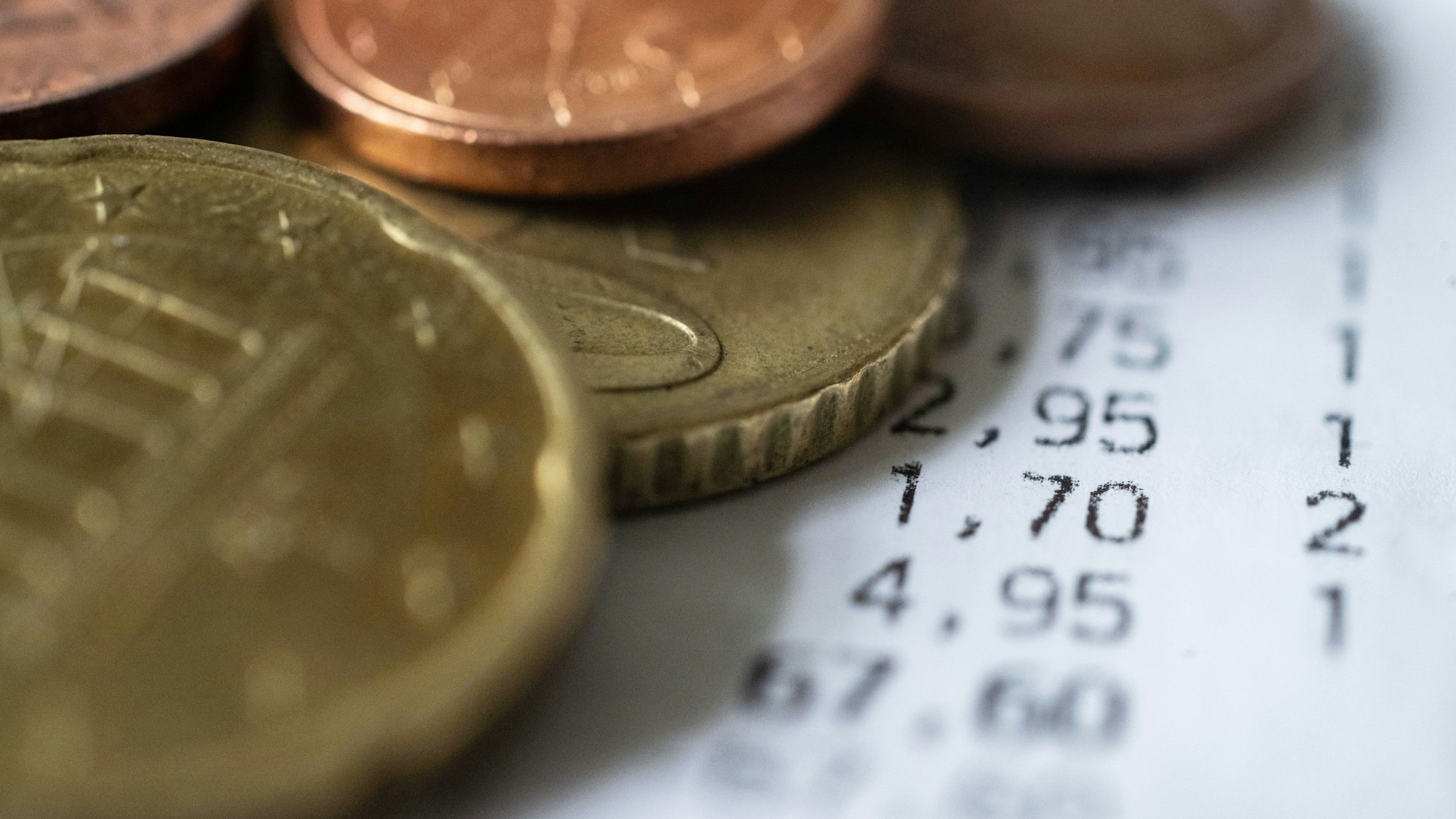 Geldmünzen liegen auf einem Kassenbon.