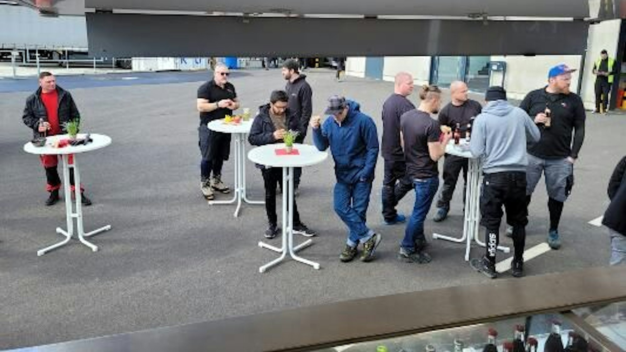 Blick aus dem Foodtruck auf Gäste, die an Stehtischen eine Mahlzeit zu sich nehmen.