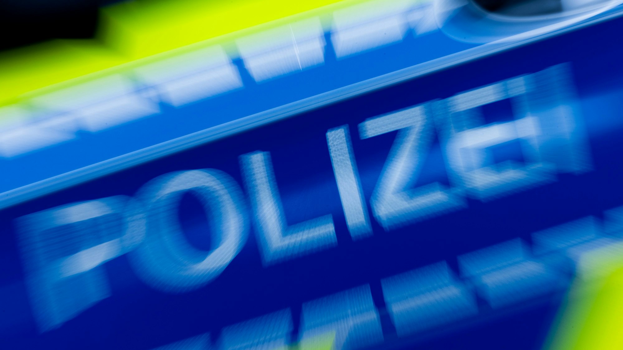 Das Foto zeigt ein verwackeltes Bild eines Polizeiautos.