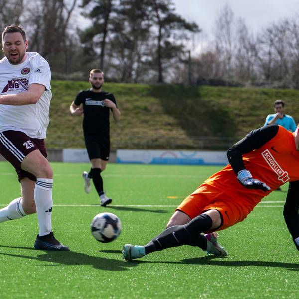 Das Bild zeigt Stefan Rempel, der den Ball gerade geschossen hat. Torhüter Jona Lorbach wirft sich ihm entgegen.