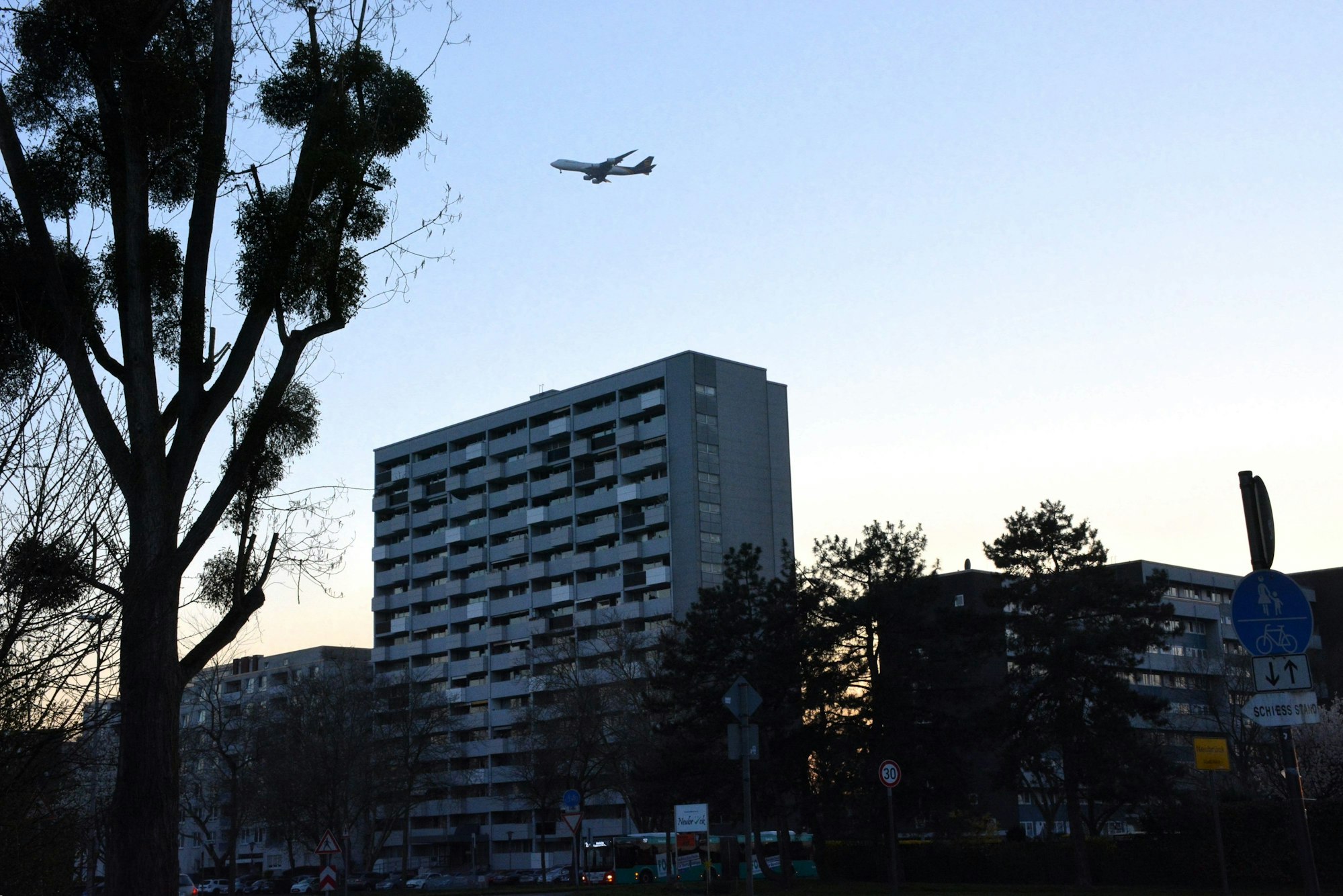 Ein Flugzeug fliegt tief über ein Hochhaus.