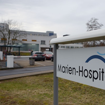 Das Bild zeigt die Einfahrt zum Krankenhaus und ein Schild mit der Auffahrt „Marien-Hospital“.