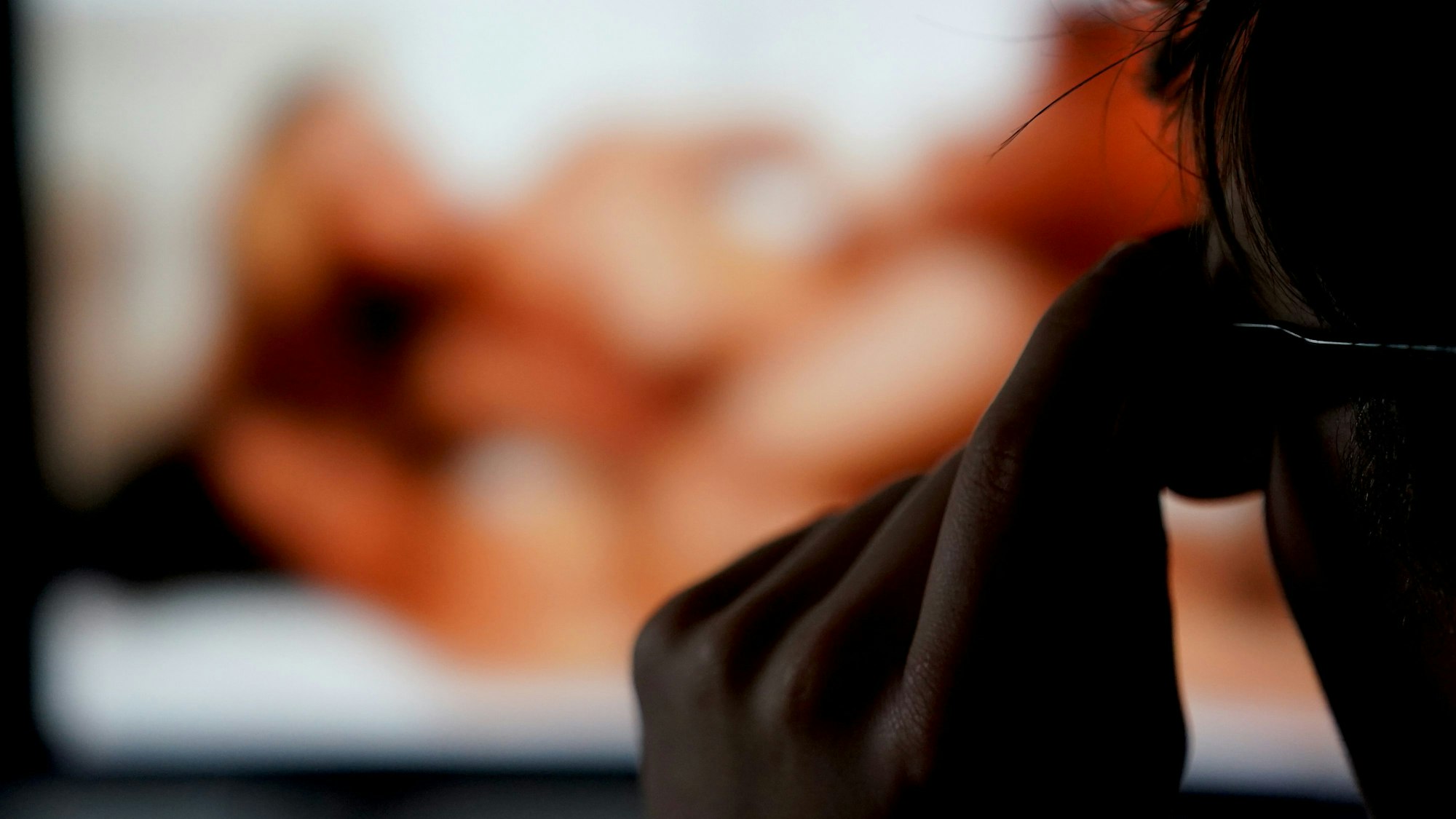 ILLUSTRATION - Ein Mann schaut sich auf einem Bildschirm eine Porno-Internetseite an. (gestellte Szene)