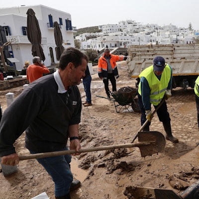 Auf der Ägäisinsel Paros schaufeln Helfer Schlamm von den Straßen.