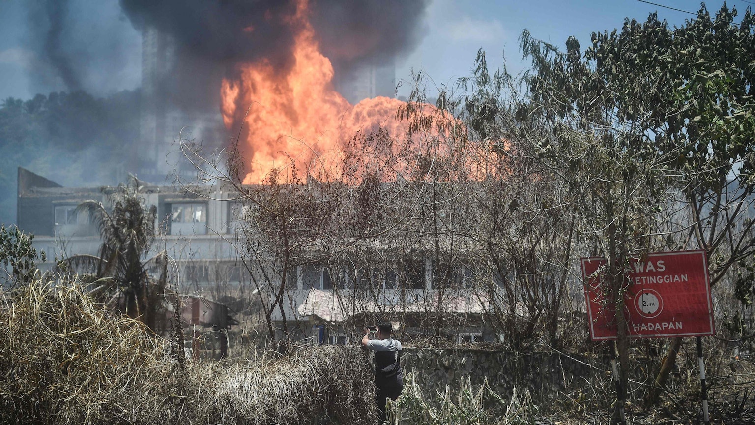 Ein Mann betrachtet das Feuer, das durch die explodierte Pipeline ausgelöst wurde.