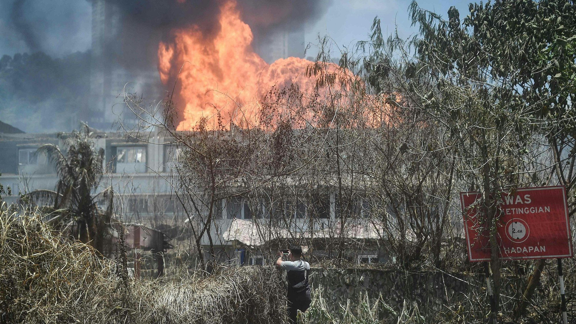 Ein Mann betrachtet das Feuer, das durch die explodierte Pipeline ausgelöst wurde.