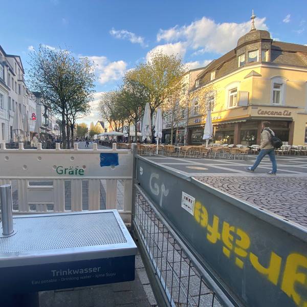 Zu sehen ist einer der Trinkwasserbrunnen, der von einem Bauzaun abgeschirmt wird.