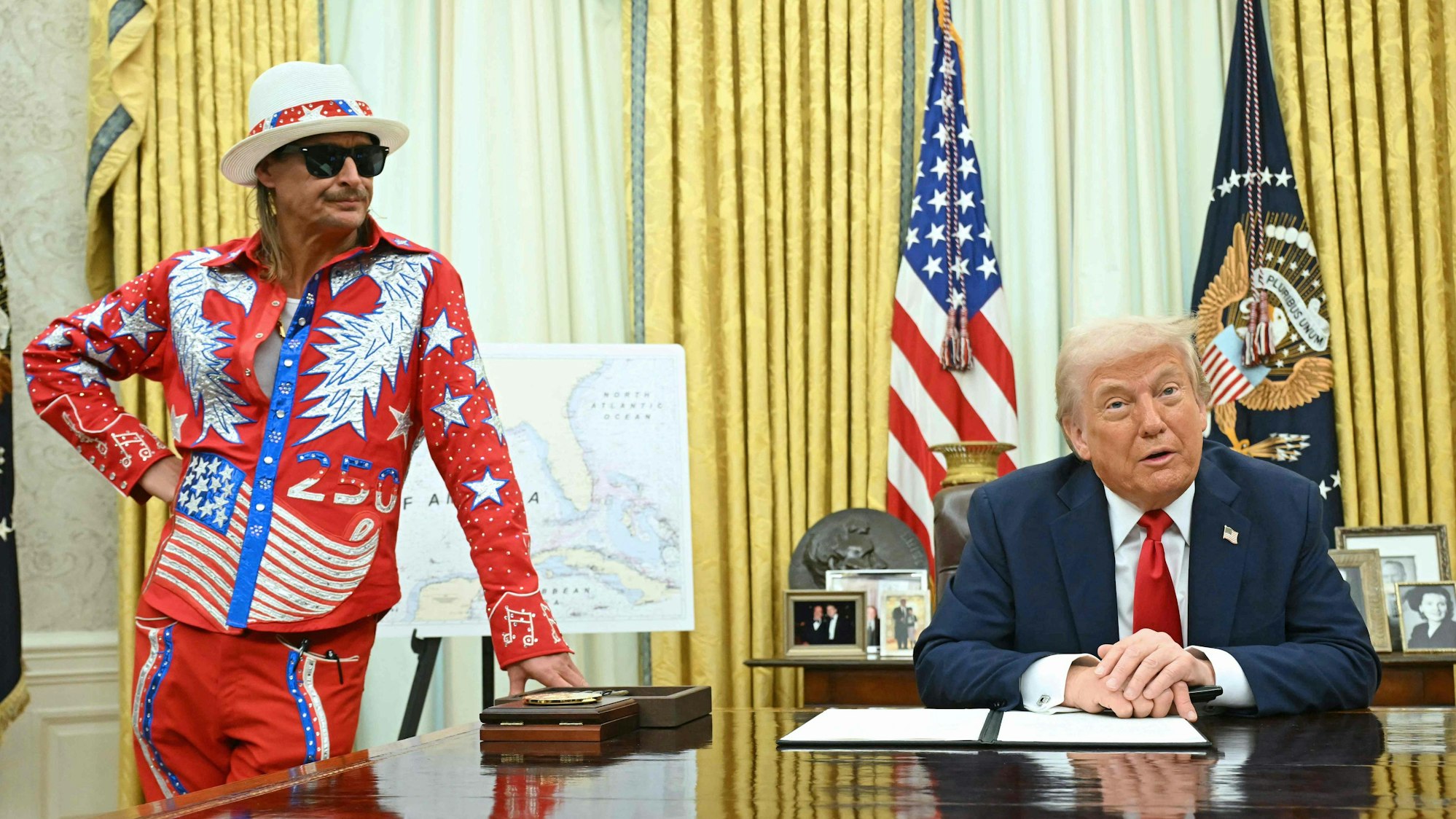 Donald Trump unterschreibt im Oval Office ein Dekret im Beisein von Sänger Kid Rock (l).
