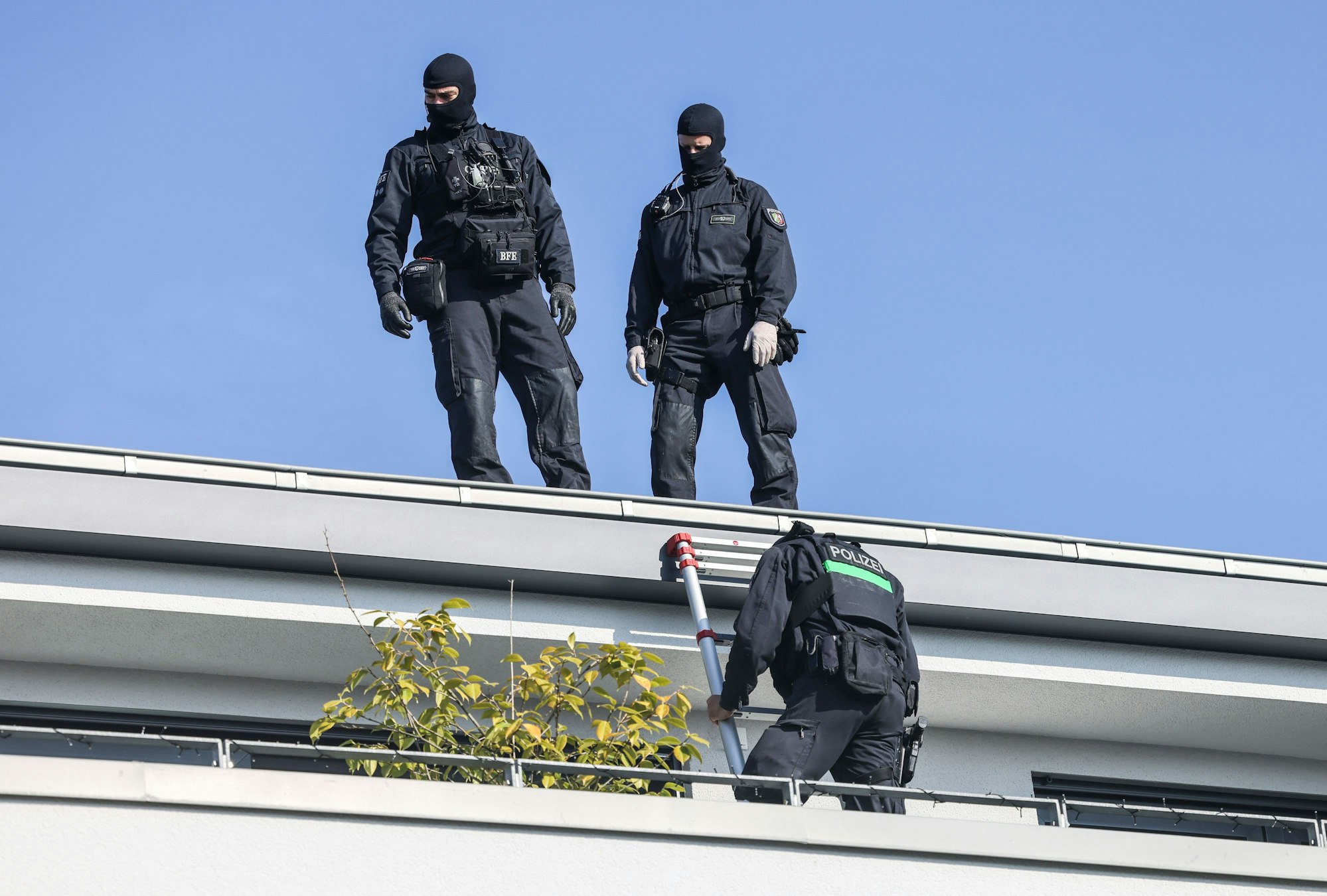 Köln: Polizisten durchsuchen den Balkon eines Wohnhauses.