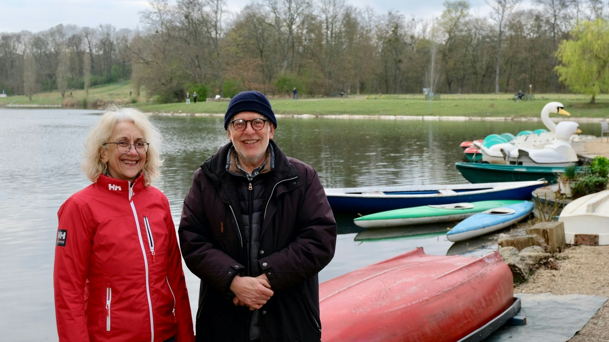 Eine Frau und ein Mann stehen an einem Weiher.