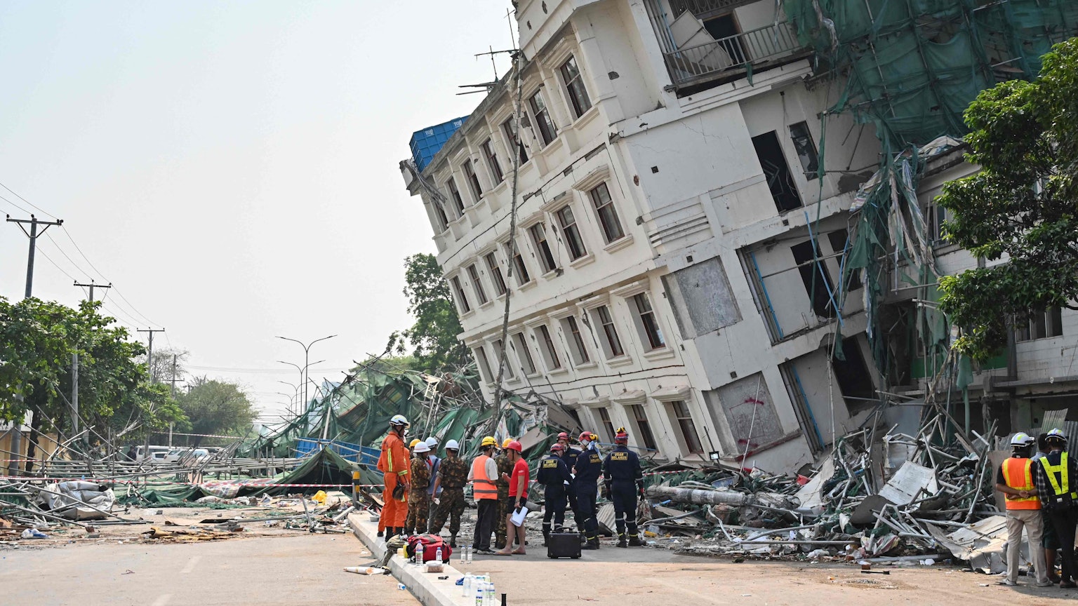 Rettungsteams an einem teilweise eingestürzten Gebäude in Mandalay.