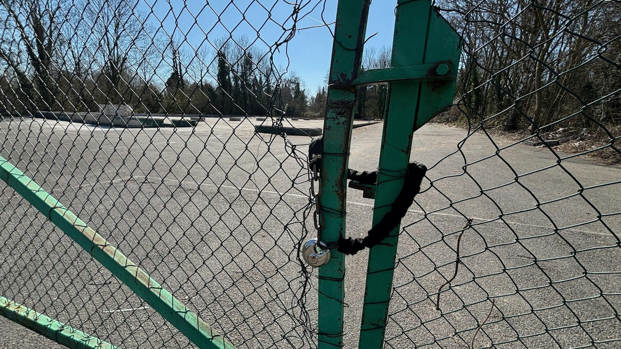 Auf dem Bild ist ein leergeräumtes Grundstück der Stadt durch eine Maschendrahtzaun zu sehen.