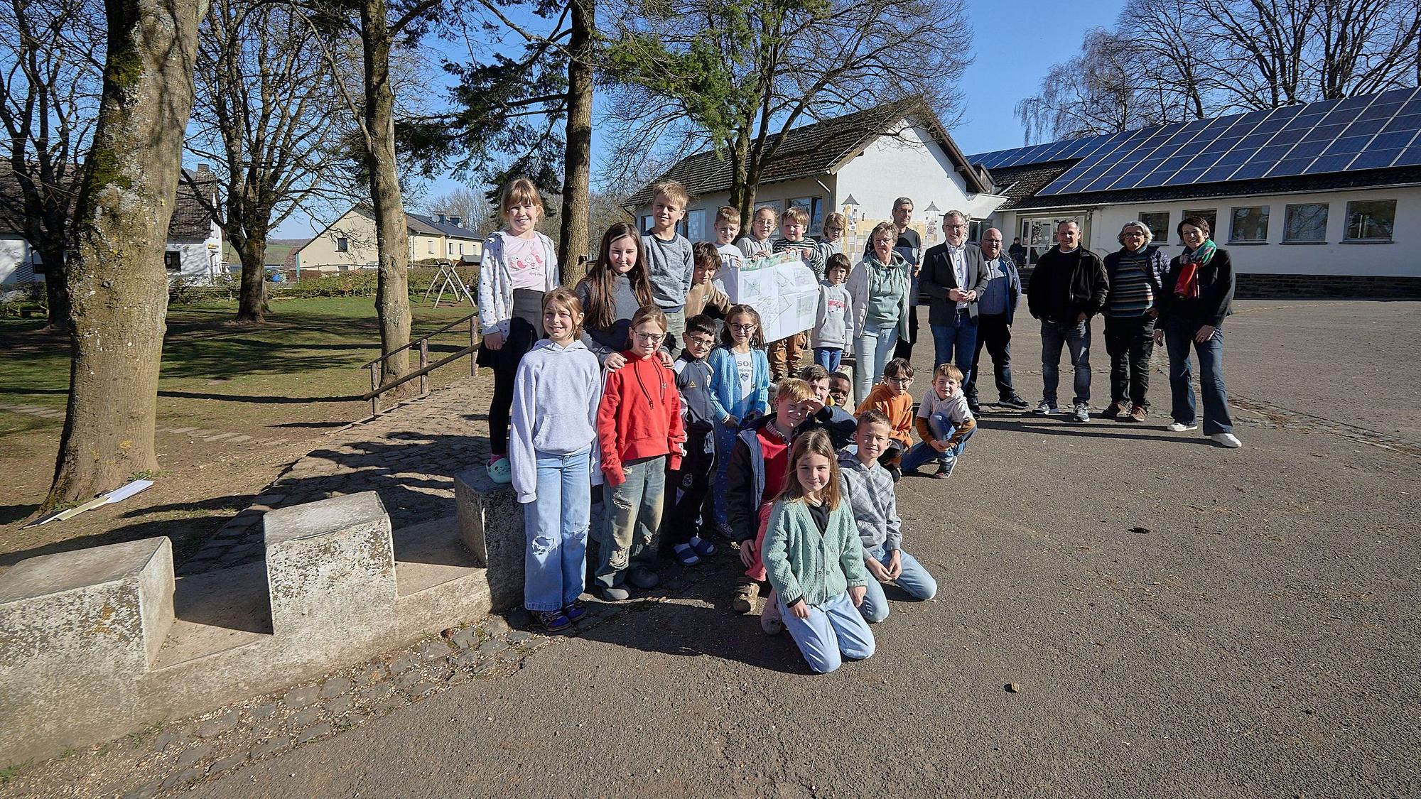 Eine Gruppe Menschen steht auf dem Schulhof in Marmagen.