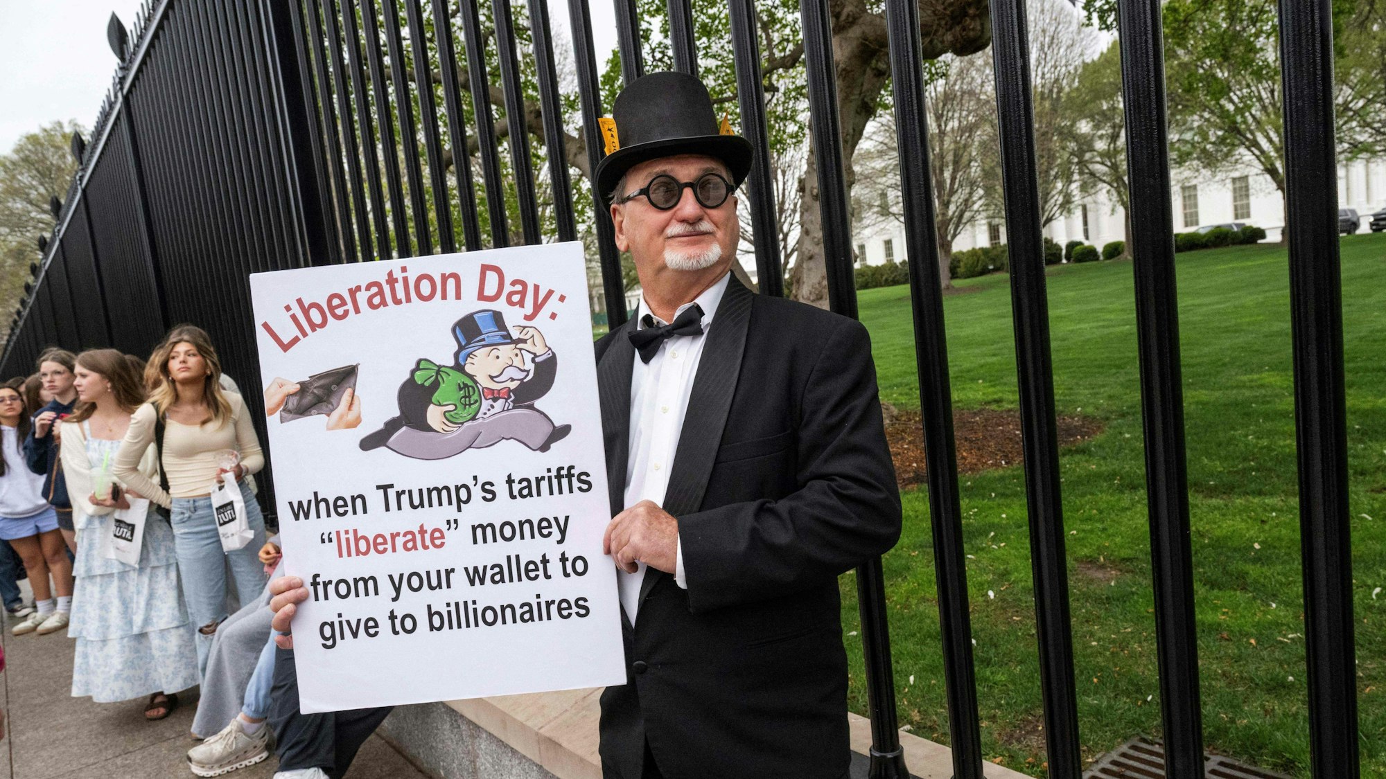 Ein 71-jähriger Einwohner Washingtons hält am 2. April 2025 vor dem Weißen Haus in Washington ein Schild, das die von US-Präsident Donald Trump verhängten Wirtschaftszölle kritisiert.