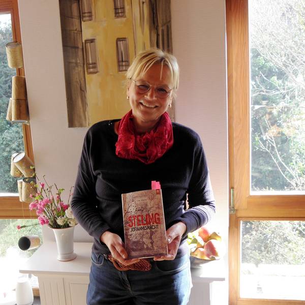 Die Autorin Ute Mainz hält ihr neues Buch in den Händen. Mit pinkfarbenen Zetteln sind einige Stellen markiert, die sie bei ihren Lesungen vortragen will.