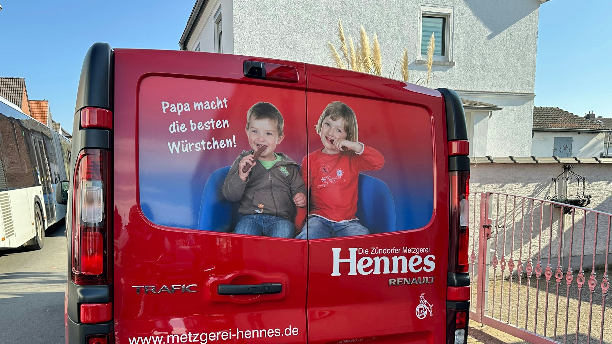 Die Rückseite eines Transporters zeigt ein Bild von einem Jungen und einem Mädchen, die von Würsten abbeißen.