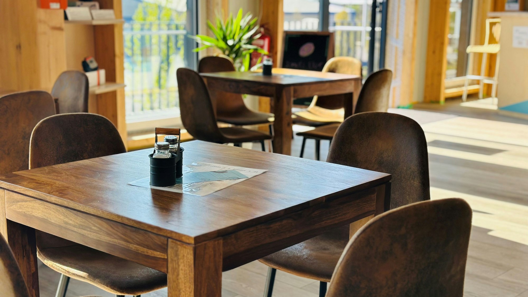 Zu sehen sind Tische mit Stühlen in einer Gastronomie.