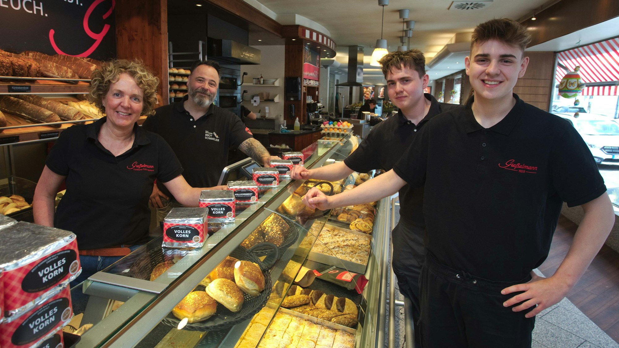 Zu sehen ist eine vierköpfige Bäckerfamilie in ihrem Cafe.