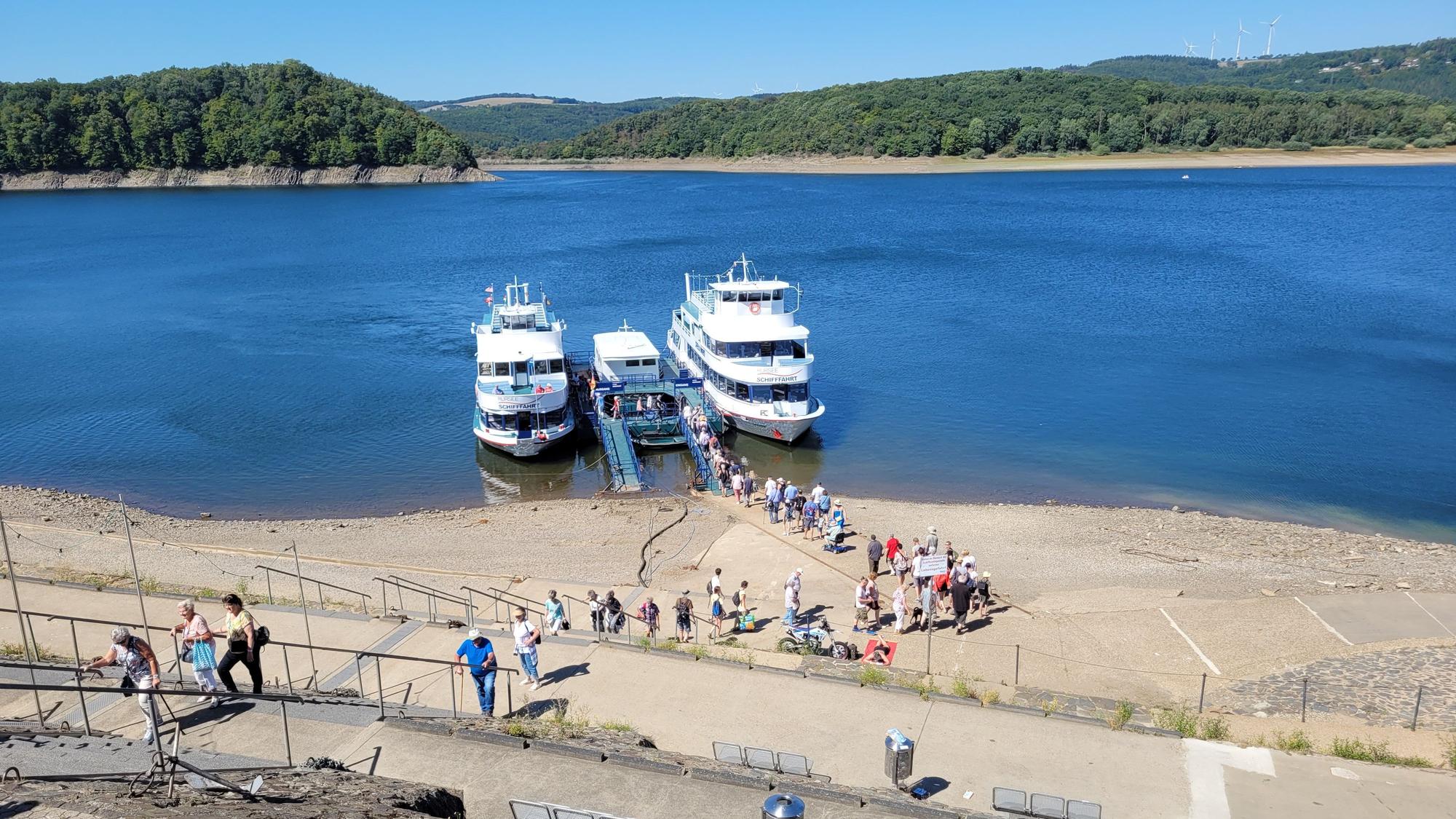Auf der nur gering gefüllten Rurtalsperre liegen zwei Ausflugsboote der Weißen Flotte.