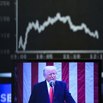 Hinter einem Fernsehmonitor, auf dem US-Präsident Donald Trump zu sehen ist, zeigt die Anzeigetafel mit der Dax-Kurve fallende Kurse