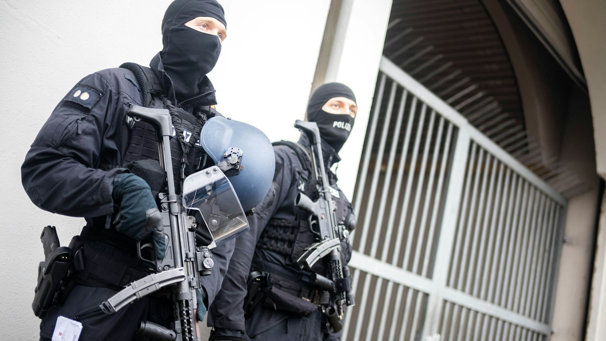 Bewaffnete Einsatzkräfte stehen vor einem Toreingang. (Symbolbild)