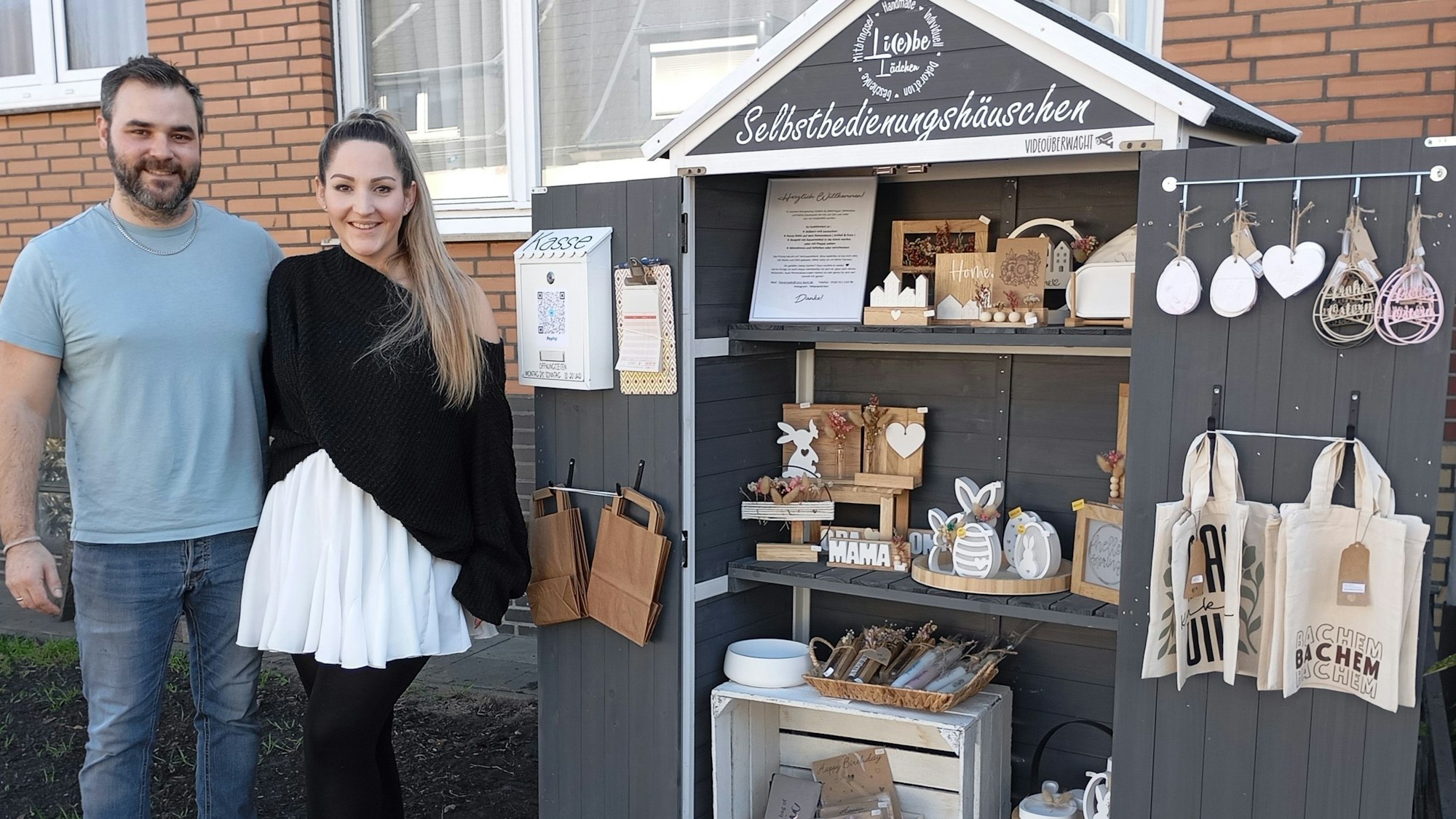 Auf dem Bild ist ein Ehepaar vor einem selbst gebauten Verkaufsstand zu sehen.
