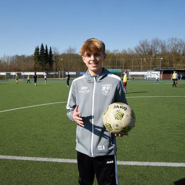 Carl Louis Altwicker steht mit einem Fußball in der Hand auf dem Fußballplatz in Nümbrecht.