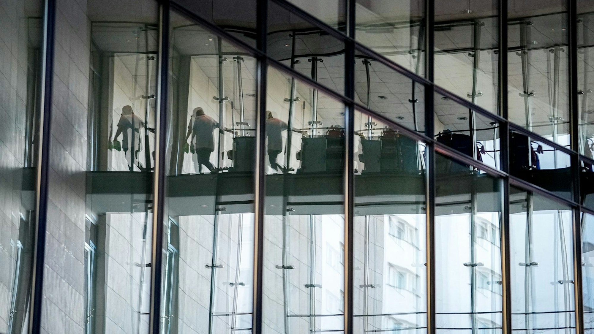 Eine Helferin spiegelt sich in der Glasfassade bei der Fortsetzung der Koalitionsverhandlungen von Union und SPD im Willy-Brandt-Haus.