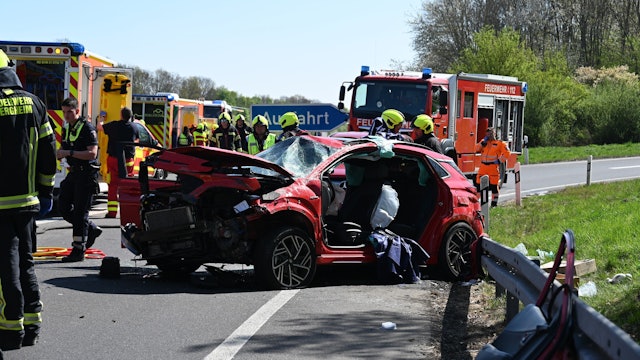 Das Bild zeigt Einsatzkräfte der Feuerwehr auf der Autobahn an einem verunglückten Auto.