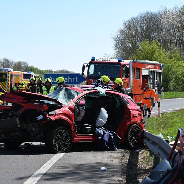 Das Bild zeigt Einsatzkräfte der Feuerwehr auf der Autobahn an einem verunglückten Auto.