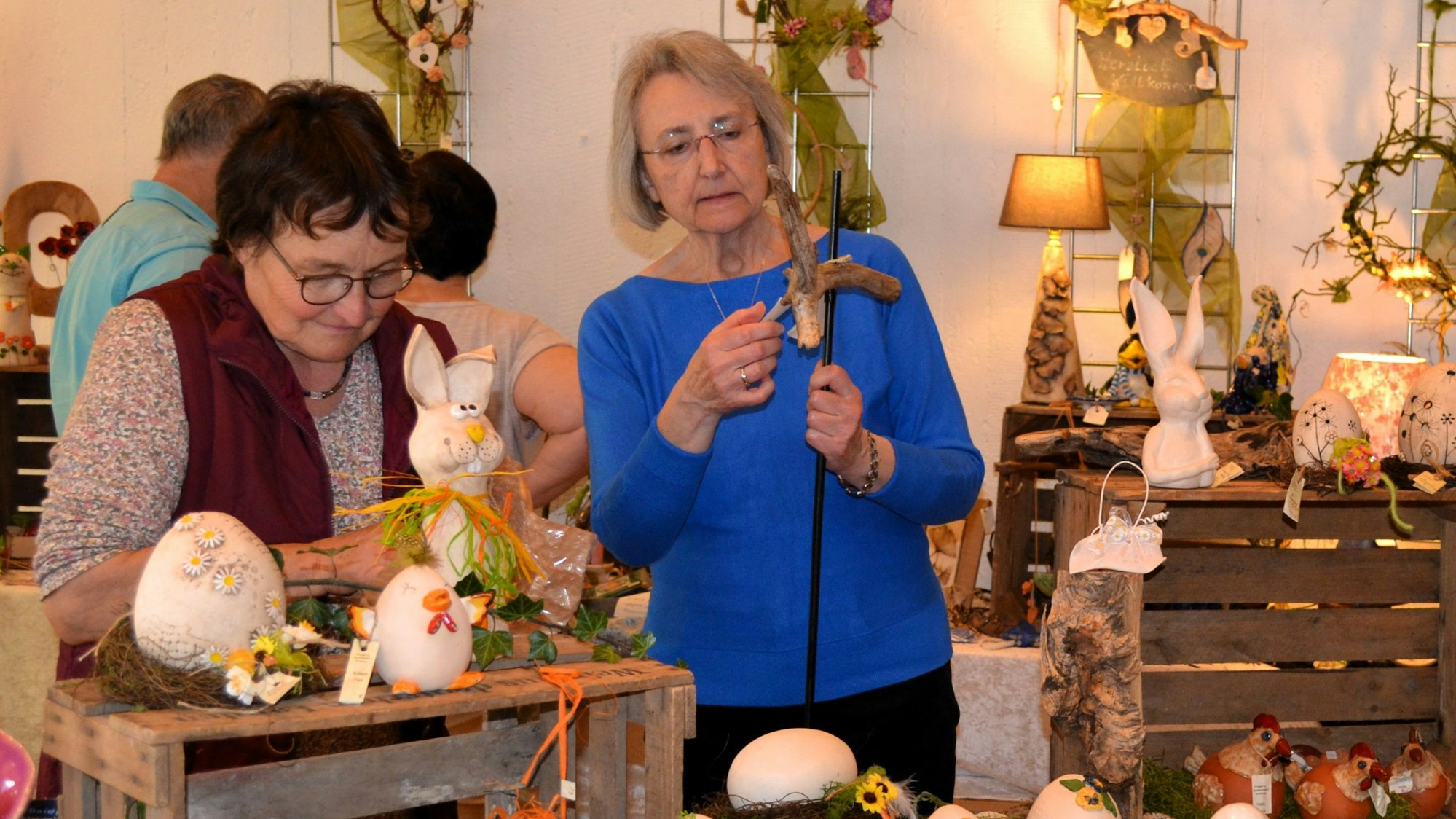 Zwei Frauen betrachten die Auslage bei einem Kunsthandwerksmarkt.