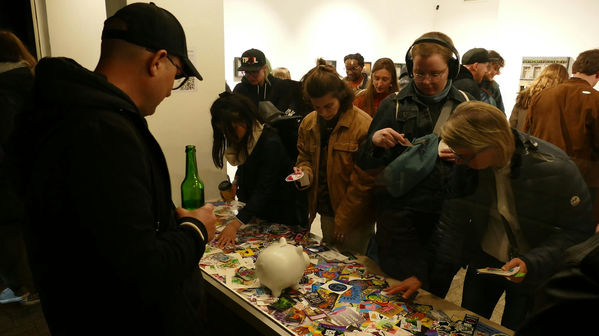 Menschen schauen anderen Menschen durchs Schaufenster beim Aussuchen von Aufklebern zu.