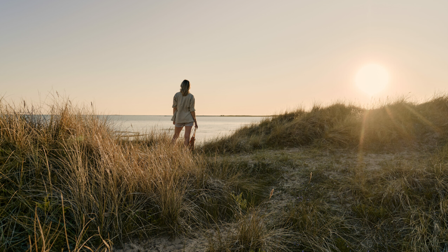 Bild vom Küstenort Falkenberg in der Region Halland. Eine Frau blickt aufs Meer.