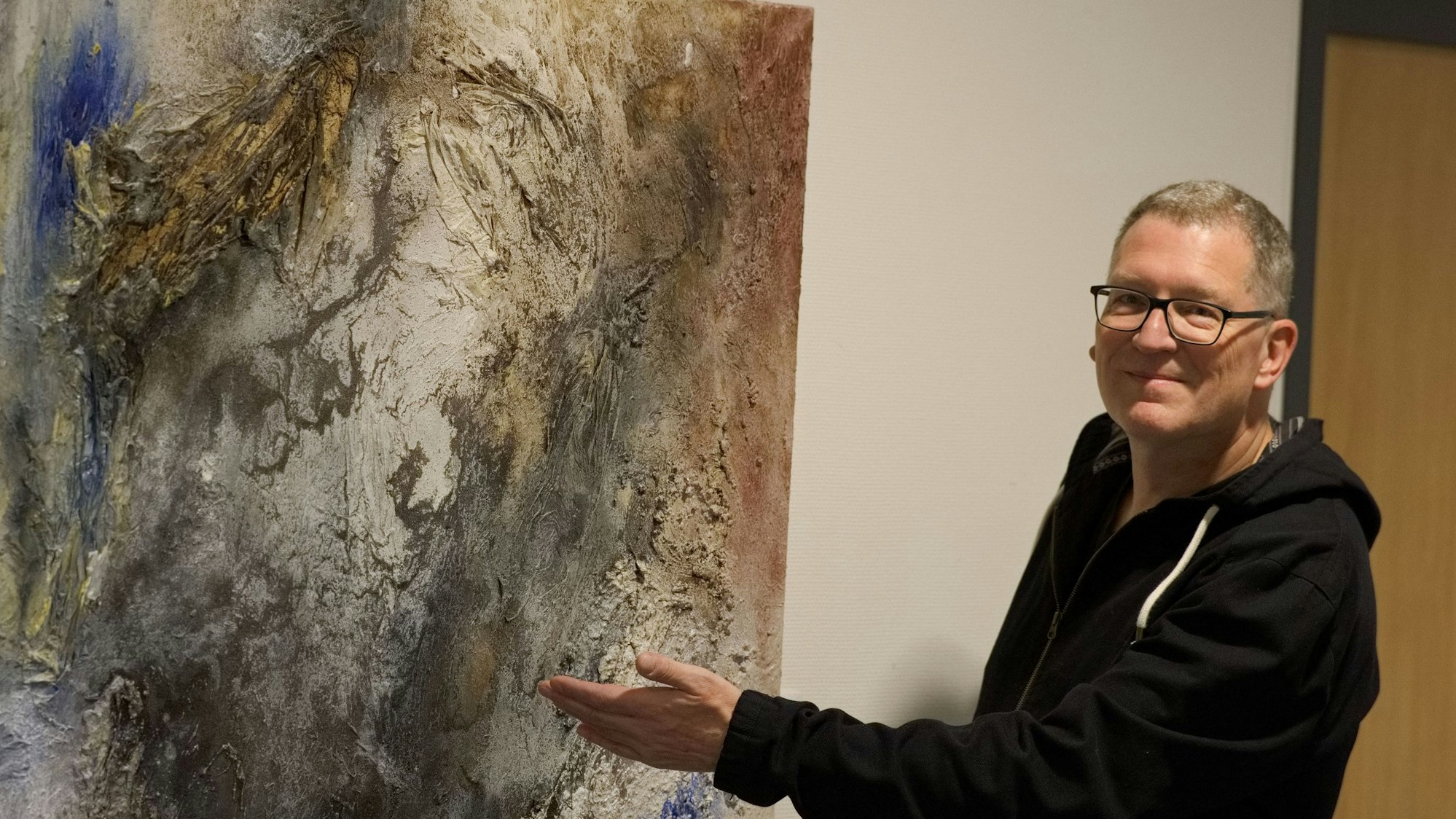 Das Bild zeigt den Künstler vor einem seiner Werke.