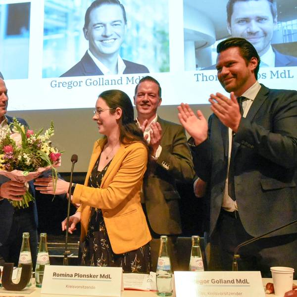 Zu sehen ist Landrat Frank Rock, der Romina Plonsker Blumen überreicht.