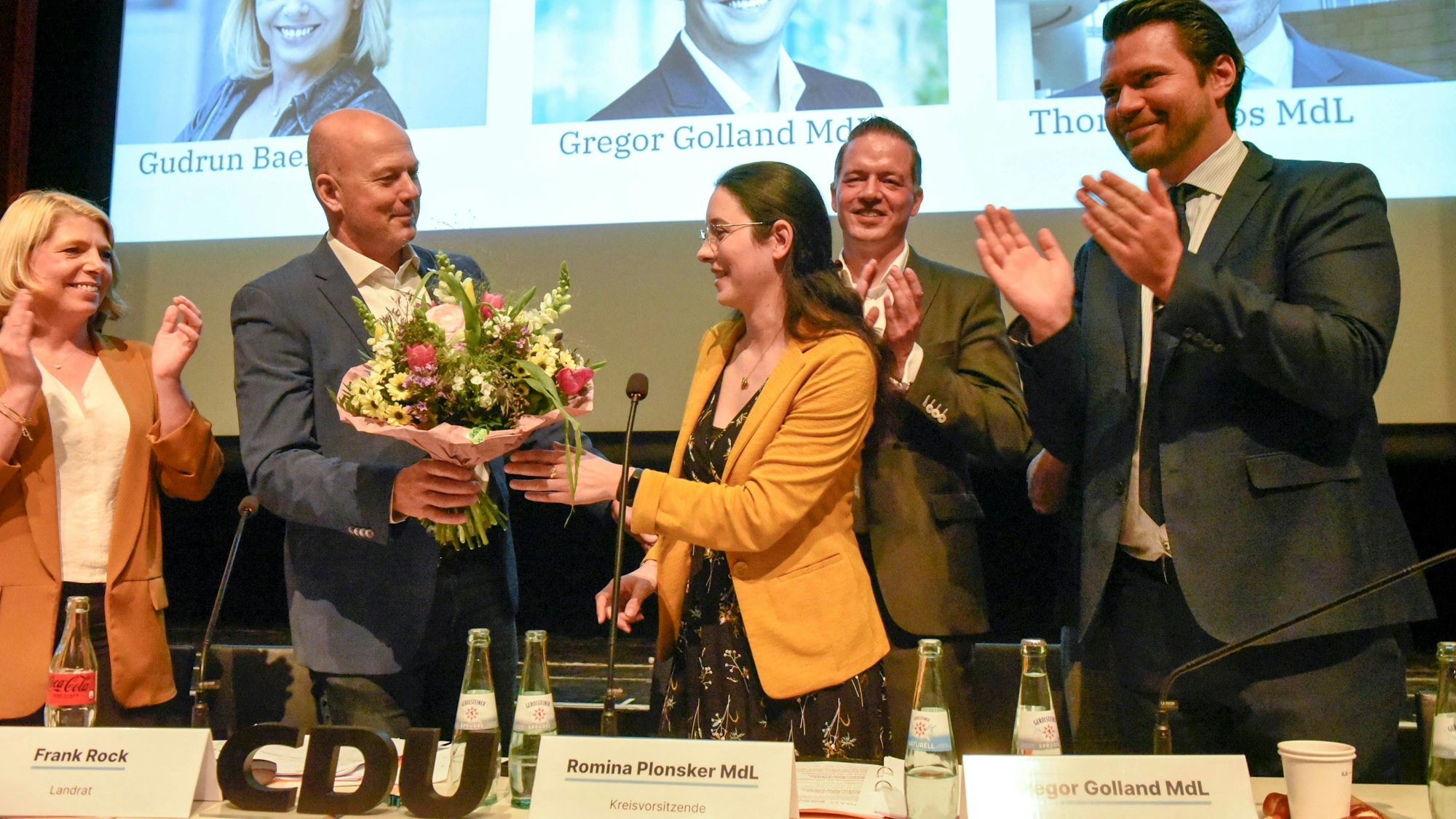 Zu sehen ist Landrat Frank Rock, der Romina Plonsker Blumen überreicht.