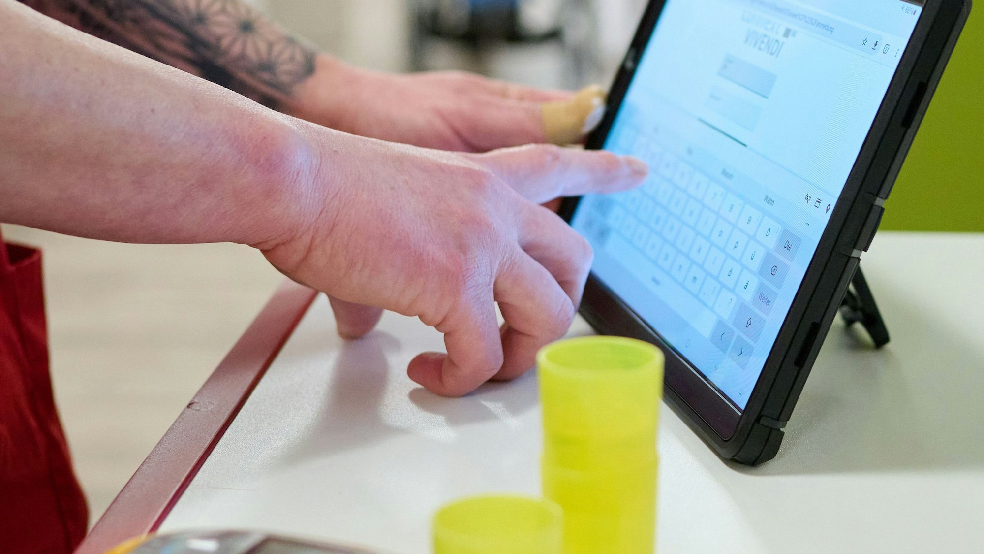 Eine Pflegekraft dokumentiert ihre Arbeit auf einem Tablet-Computer im DRK-Pflegezentrum Solferino.