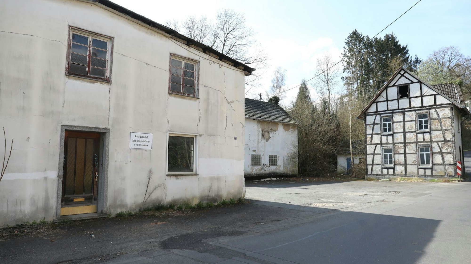 Mehrere marode Gebäude, eines davon mit Fachwerk.