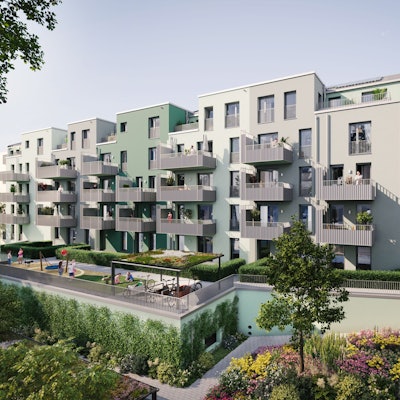 Mehrere Häuser mit Balkonen sind über einen grünen Innenhof mit Spielplätzen und Bepflanzungen aus zu sehen.