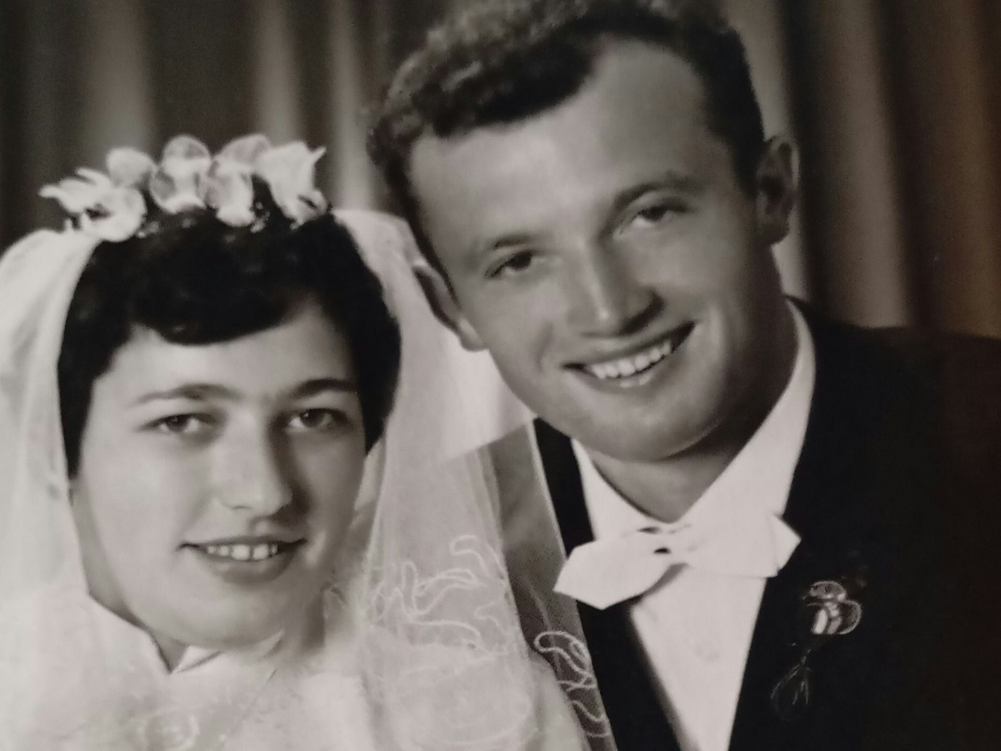 Zu sehen ist ein Brautpaar an seinem Hochzeitstag in schwarz-weiß.