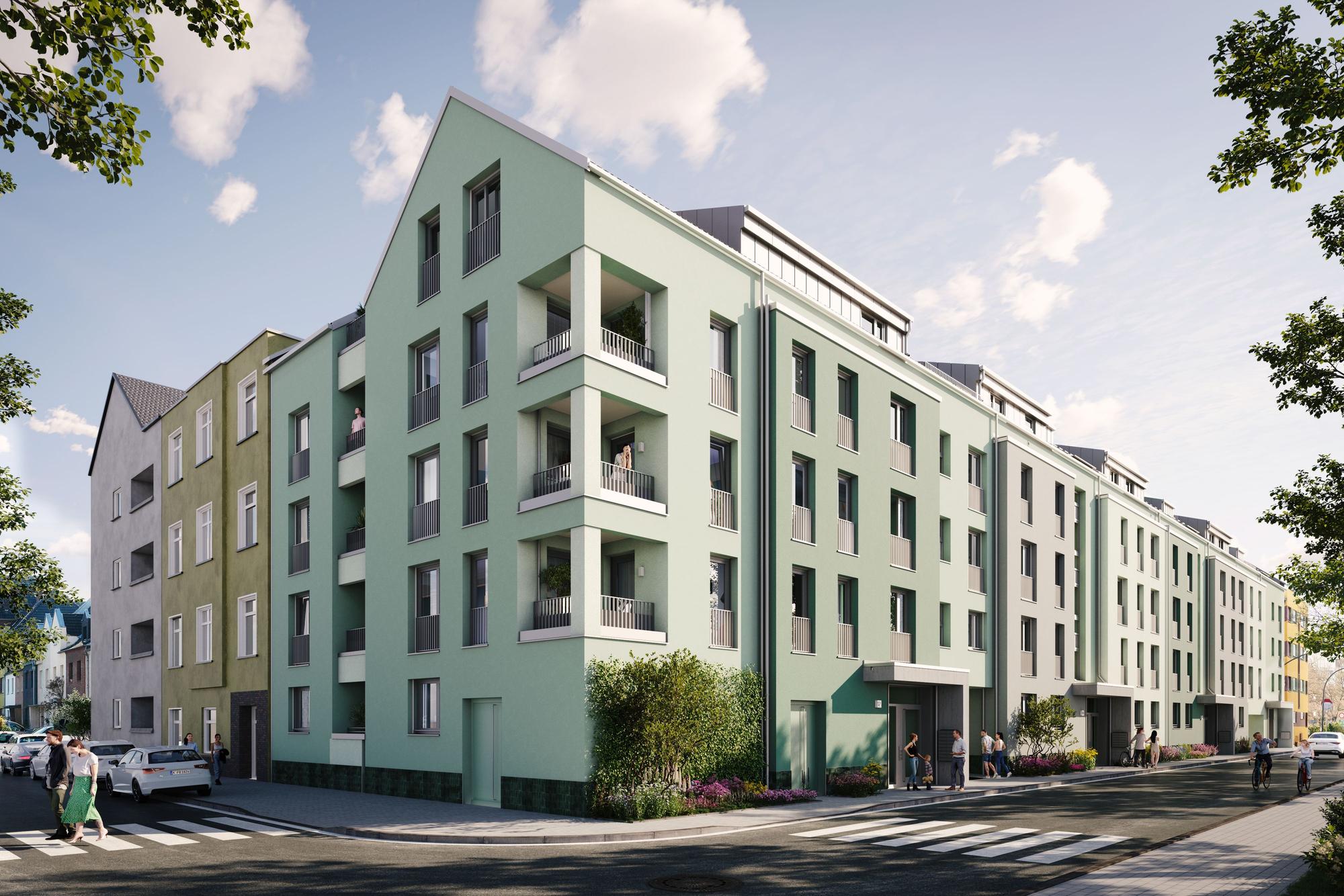 Blick auf einen Gebäuderiegel an einer Straßenecke. Die Fassade ist lindgrün.