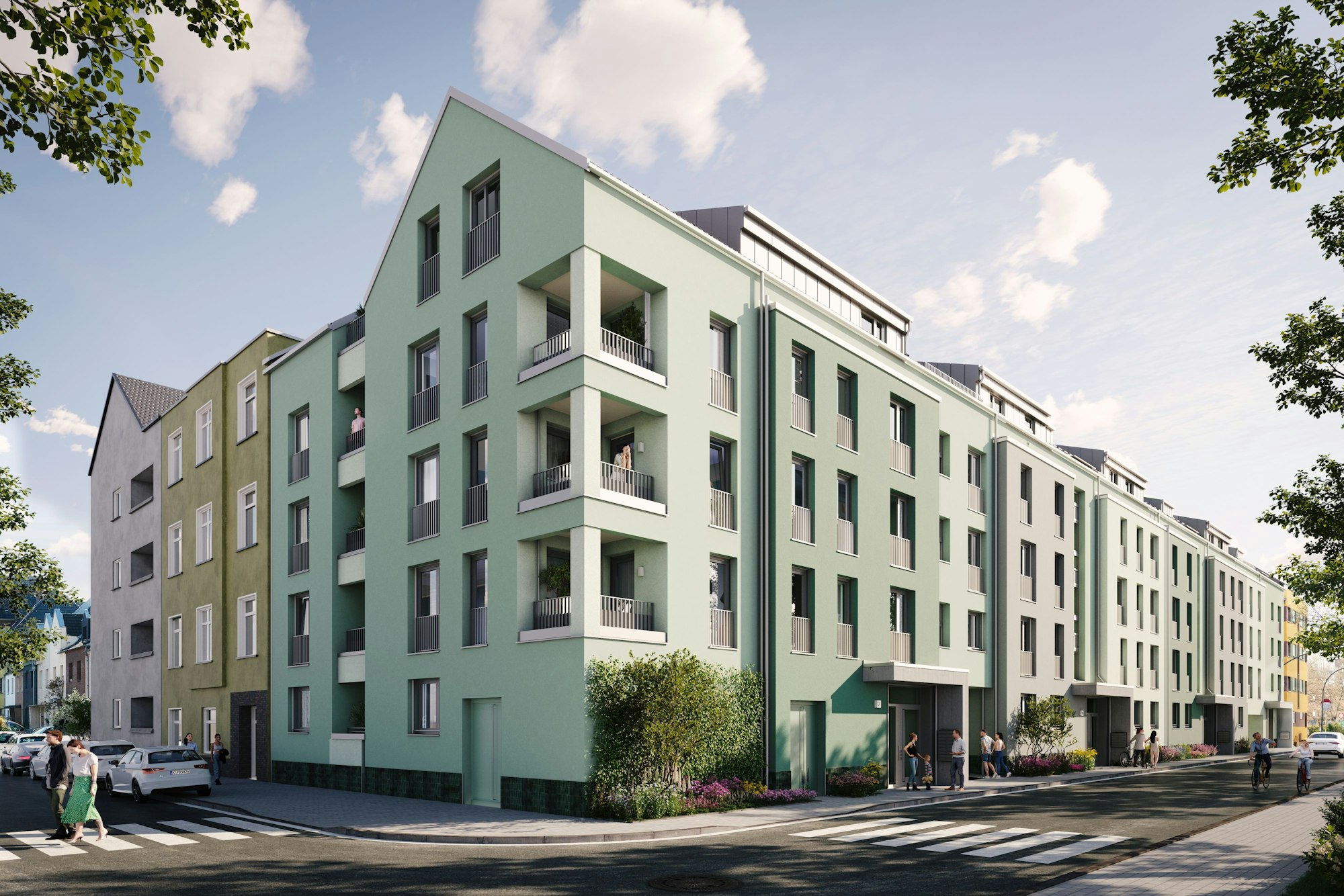 Blick auf einen Gebäuderiegel an einer Straßenecke. Die Fassade ist lindgrün.