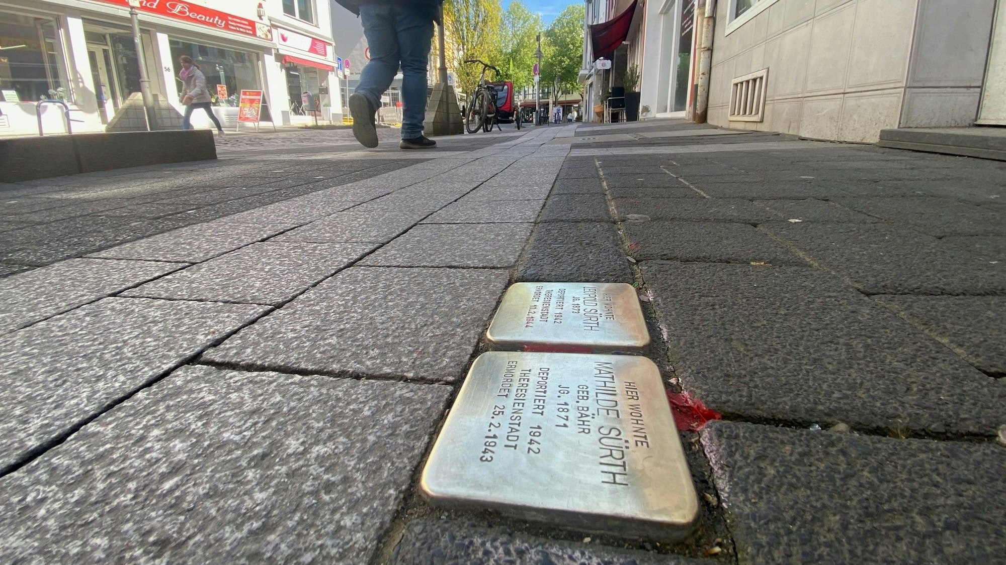 Zu sehen sind zwei Stolpersteine, die in einem Gehwegpflaster eingelassen sind.