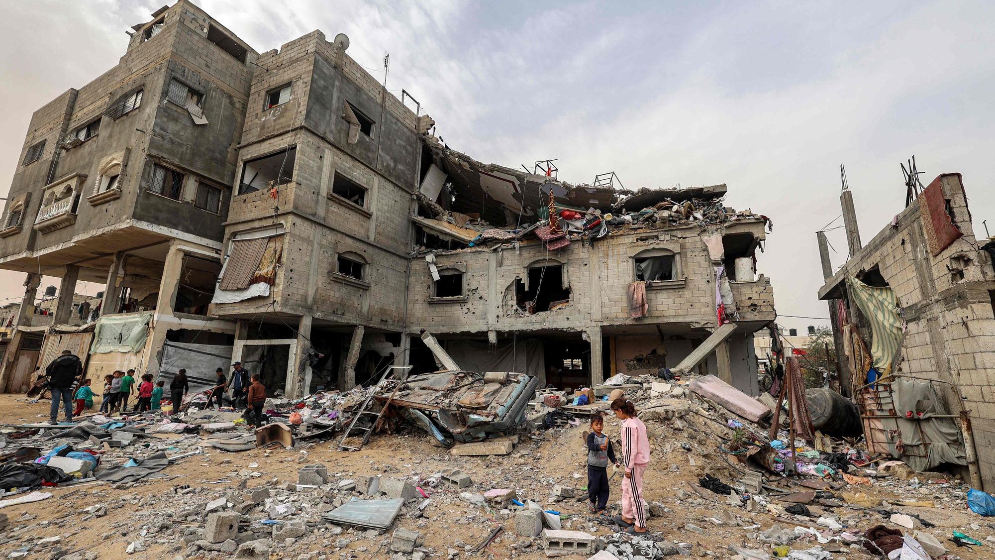 TOPSHOT - Children stand outside the Sabah family building that was hit by Israeli air strikes in Deir el-Balah in the central Gaza Strip on April 8, 2025.