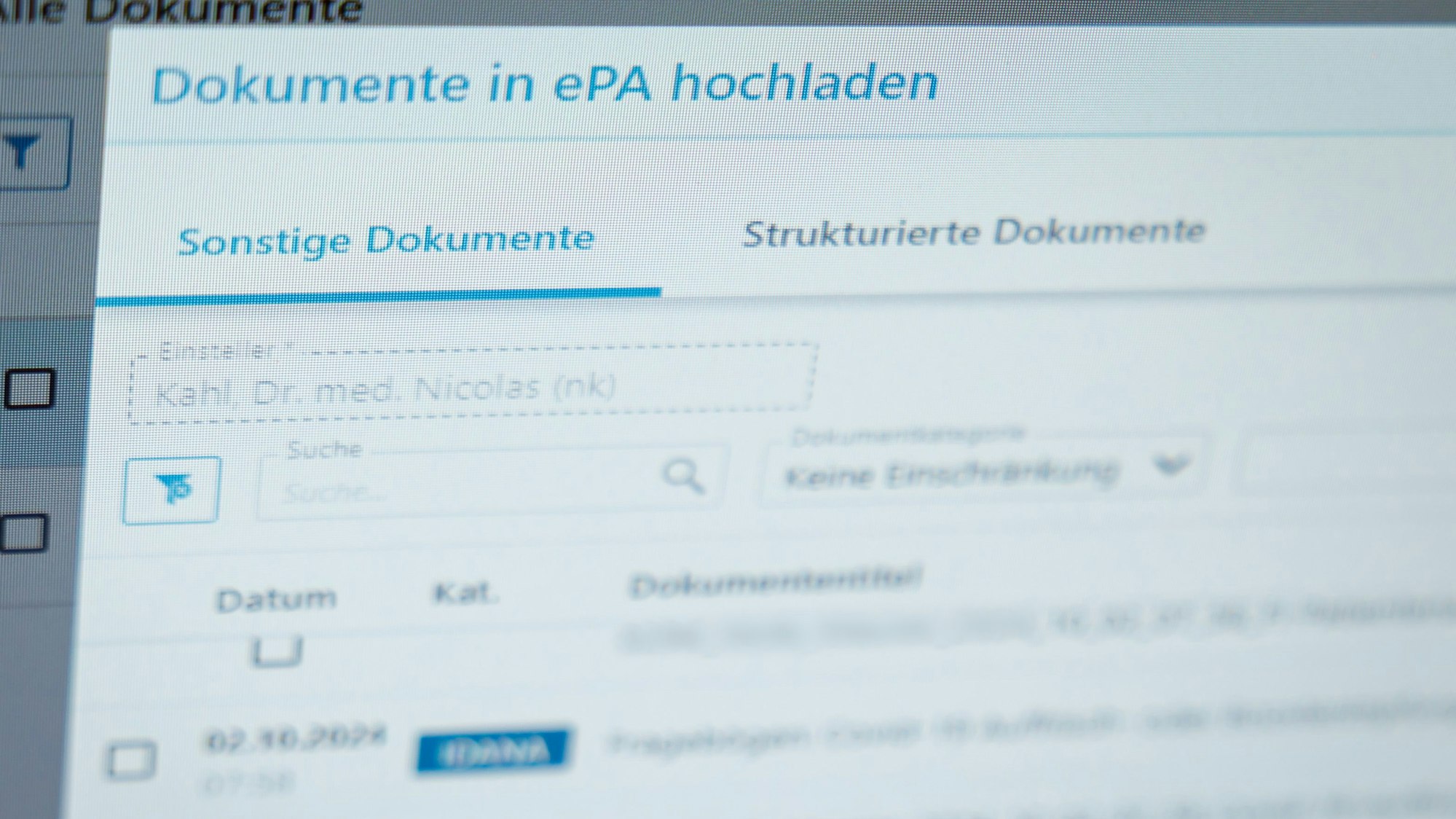 Ein Hausarzt lädt in seiner Praxis Dokumente in eine elektronische Patientenakte „ePA“.