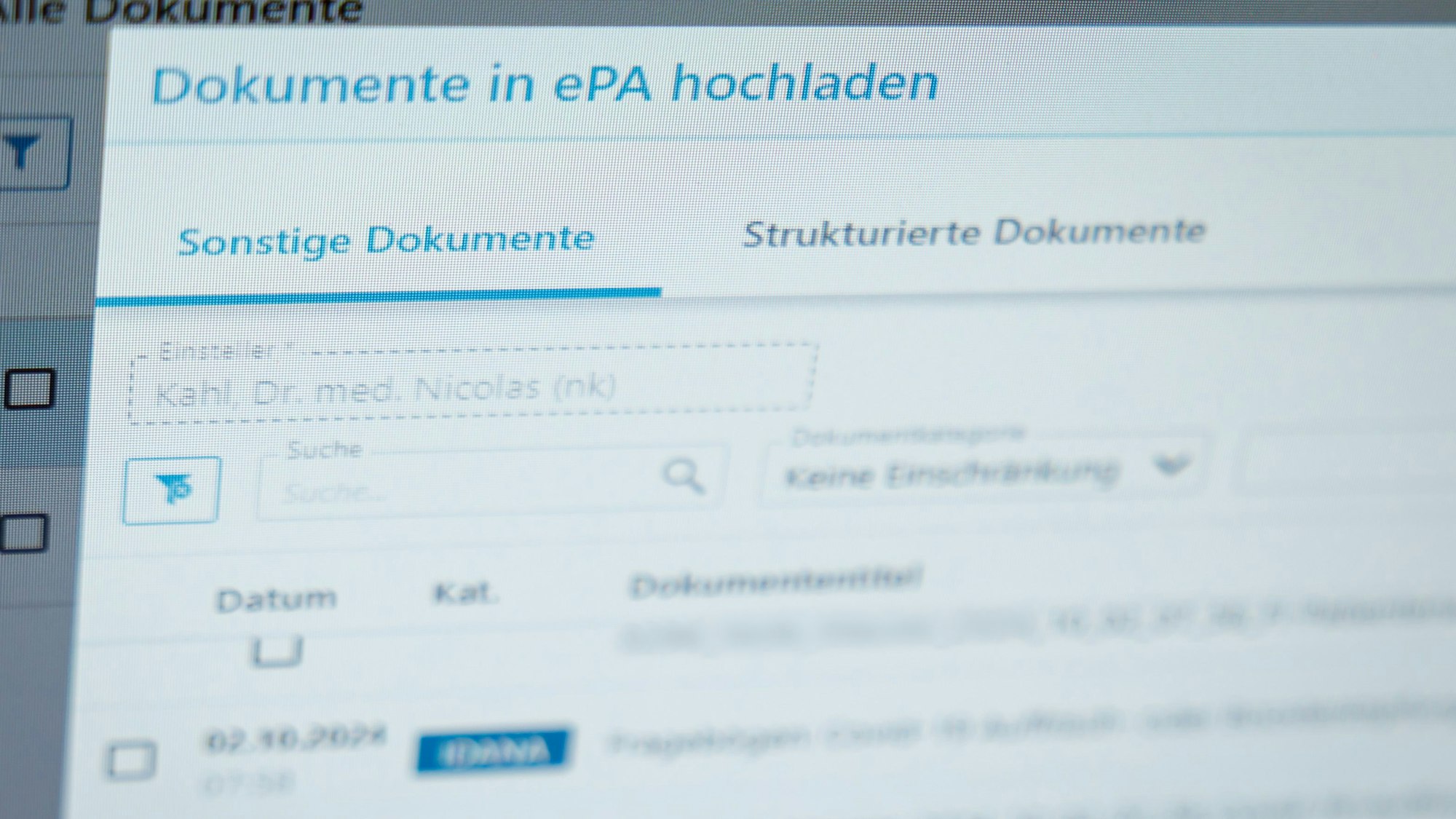 Ein Hausarzt lädt in seiner Praxis Dokumente in eine elektronische Patientenakte „ePA“.