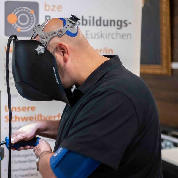 Ein Mann übt mithilfe eines Simulators das Schweißen. Funken sprühen dabei nur am Monitor.